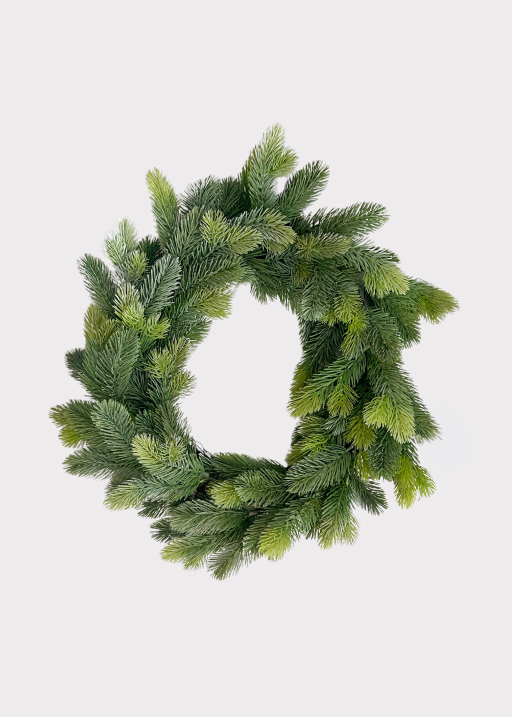 An artificial green pine wreath with realistic needle textures