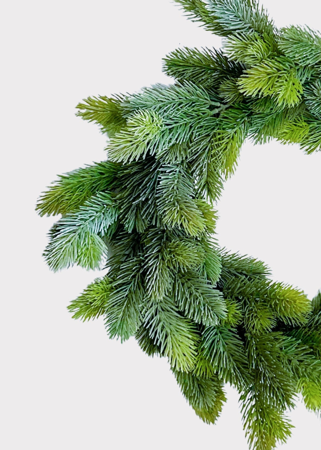 An artificial green pine wreath with realistic needle textures