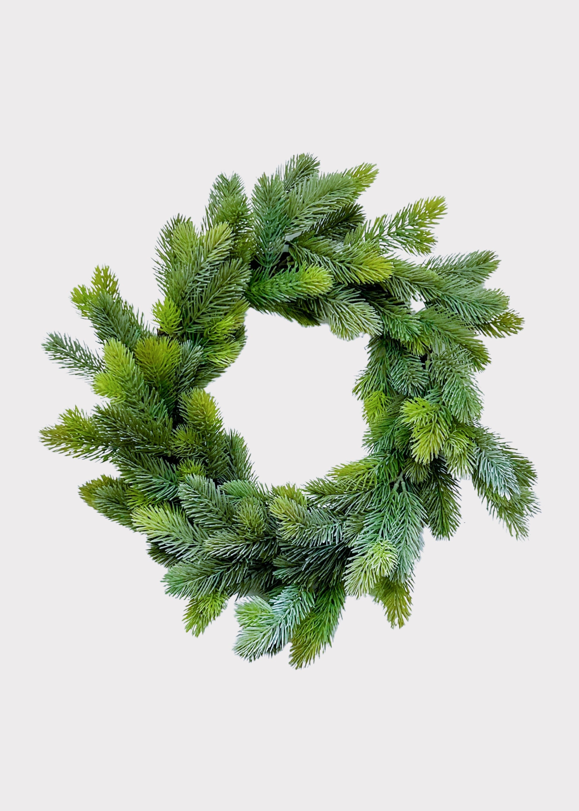 An artificial green pine wreath with realistic needle textures