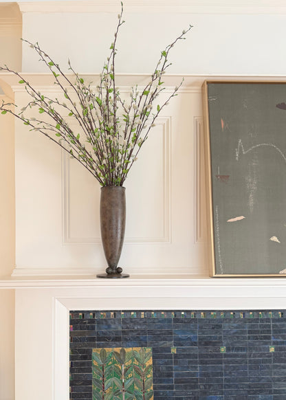 Decorative vase with pussy willow branches on a mantelpiece