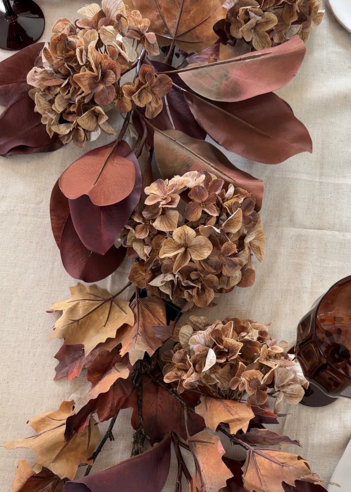 fall table decor with faux hydrangeas and magnolia leaves