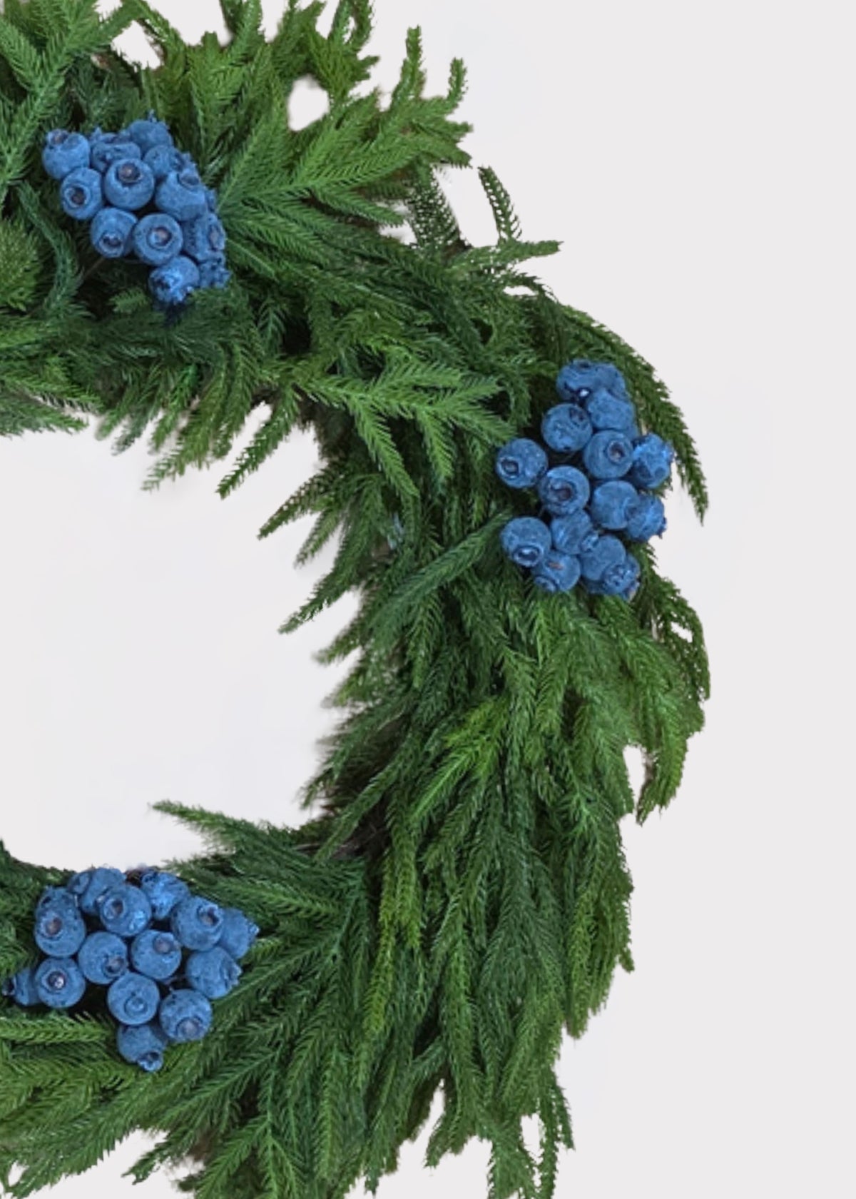 faux blue berries on a norfolk pine wreath