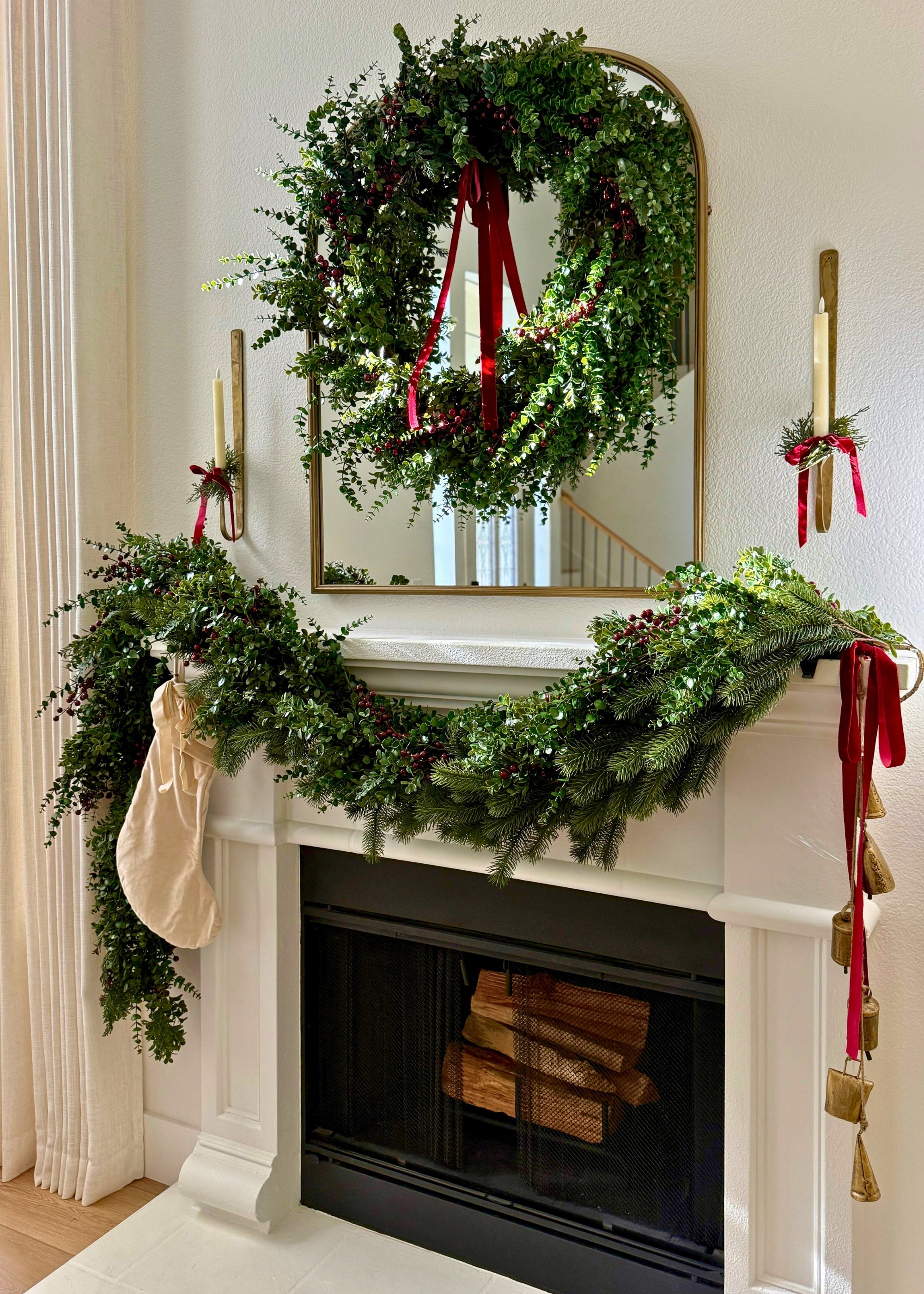 eucalyptus and red berry wreath and garland decorating a holiday mantel