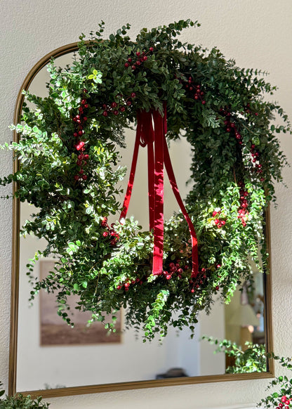 eucalyptus and red berry wreath hung on a mirror