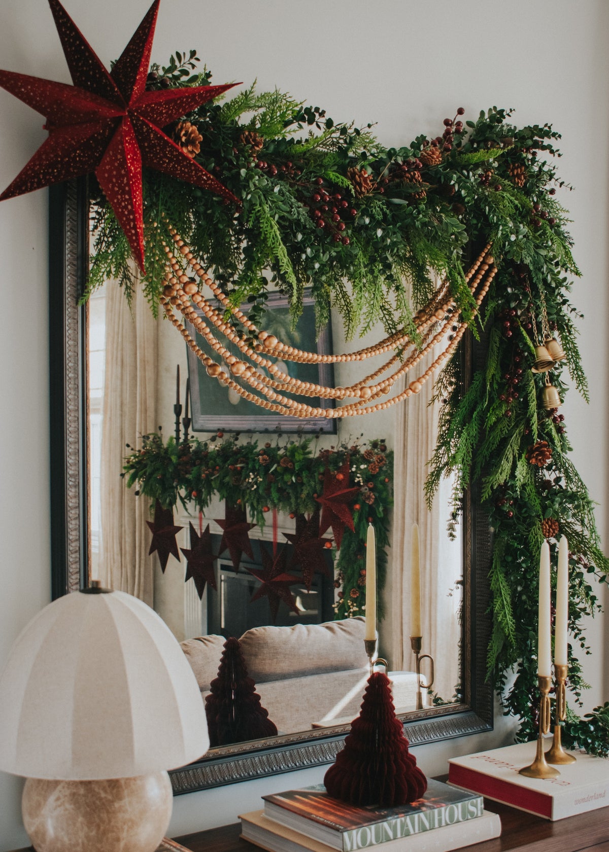 Decorative Christmas garlands of cedar and eucalyptus with red berries styled on a mirror