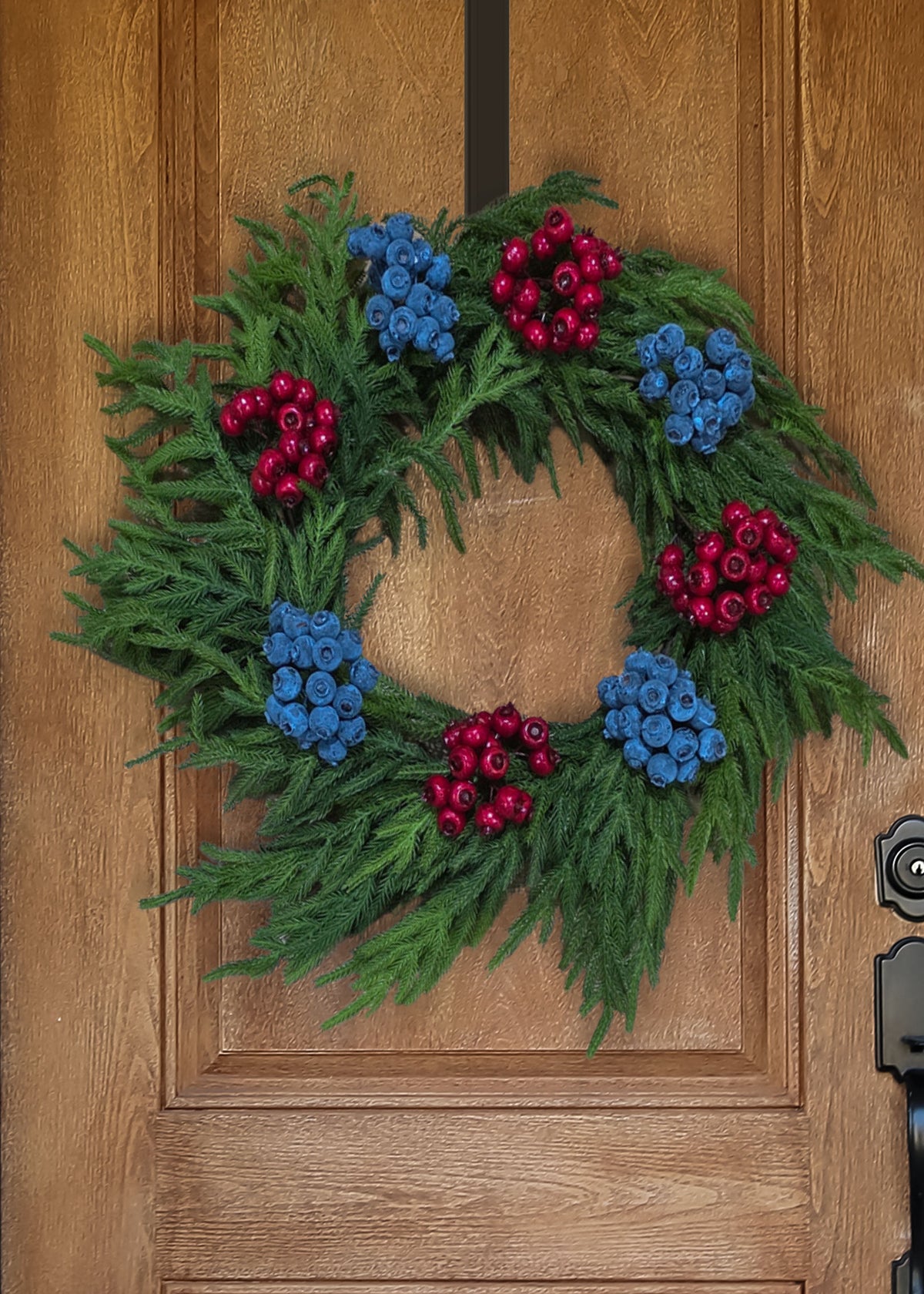 norfolk wreath with blue and red berries