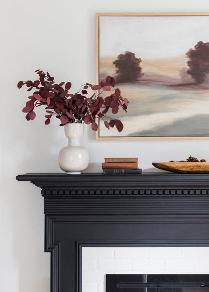 Preserved red eucalyptus styled in a vase on a mantel