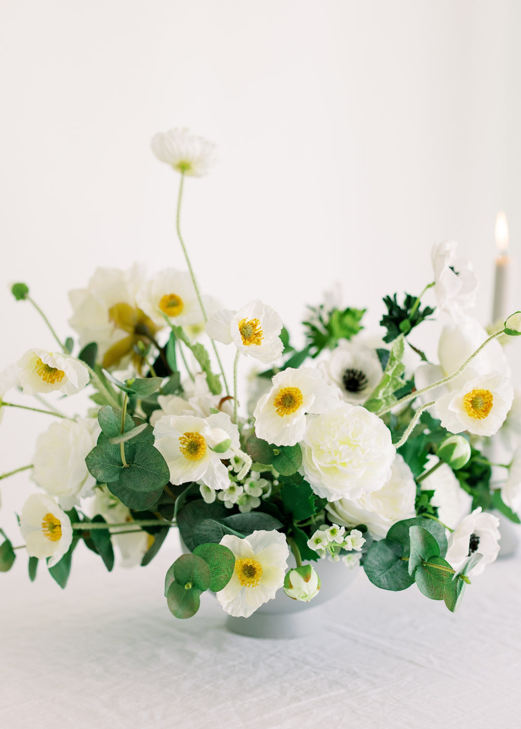 Floral arrangement with white ranunculus, anemones, and popppies