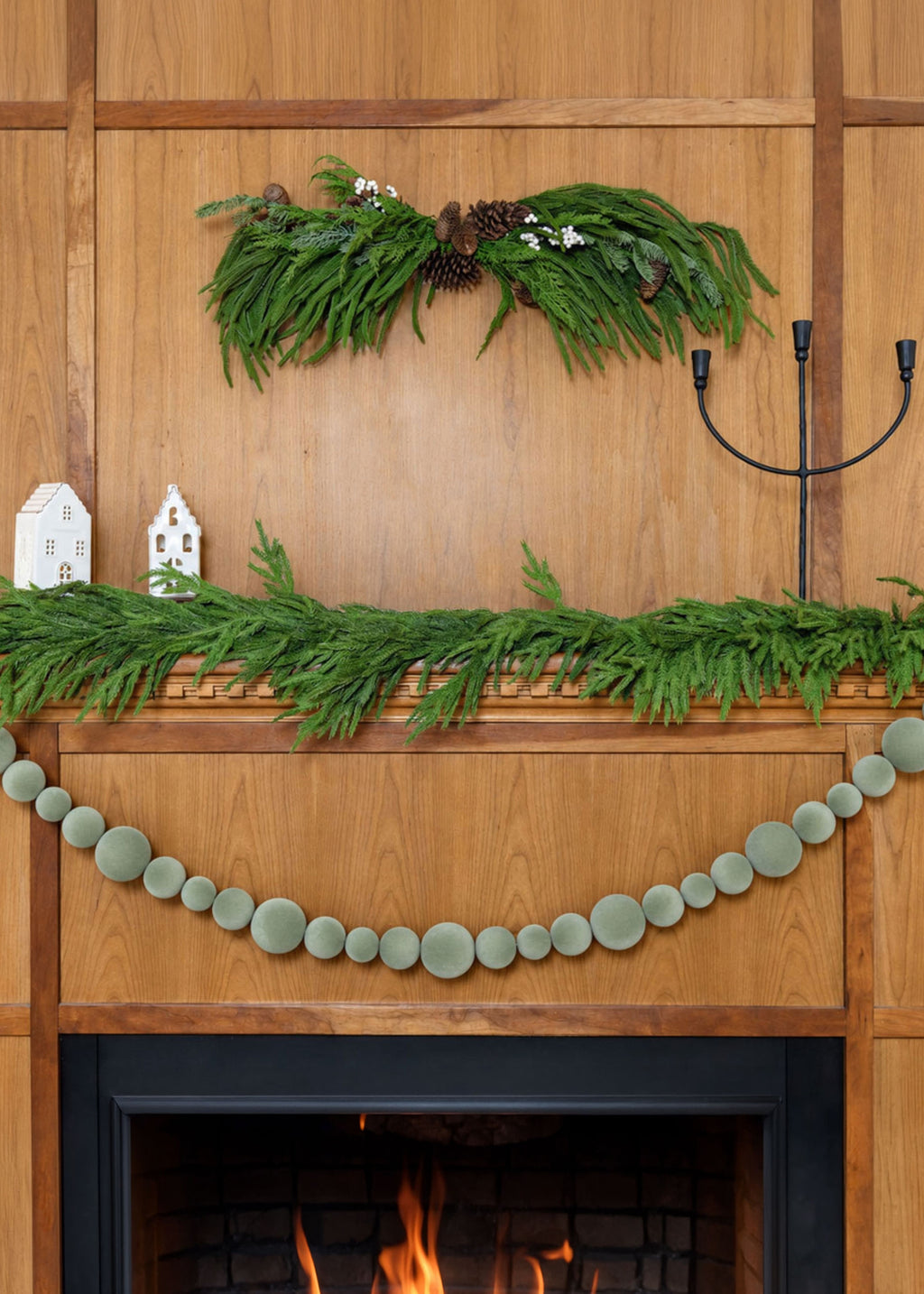mantel decorated with pine swag, norfolk garland, and flocked ornament garland