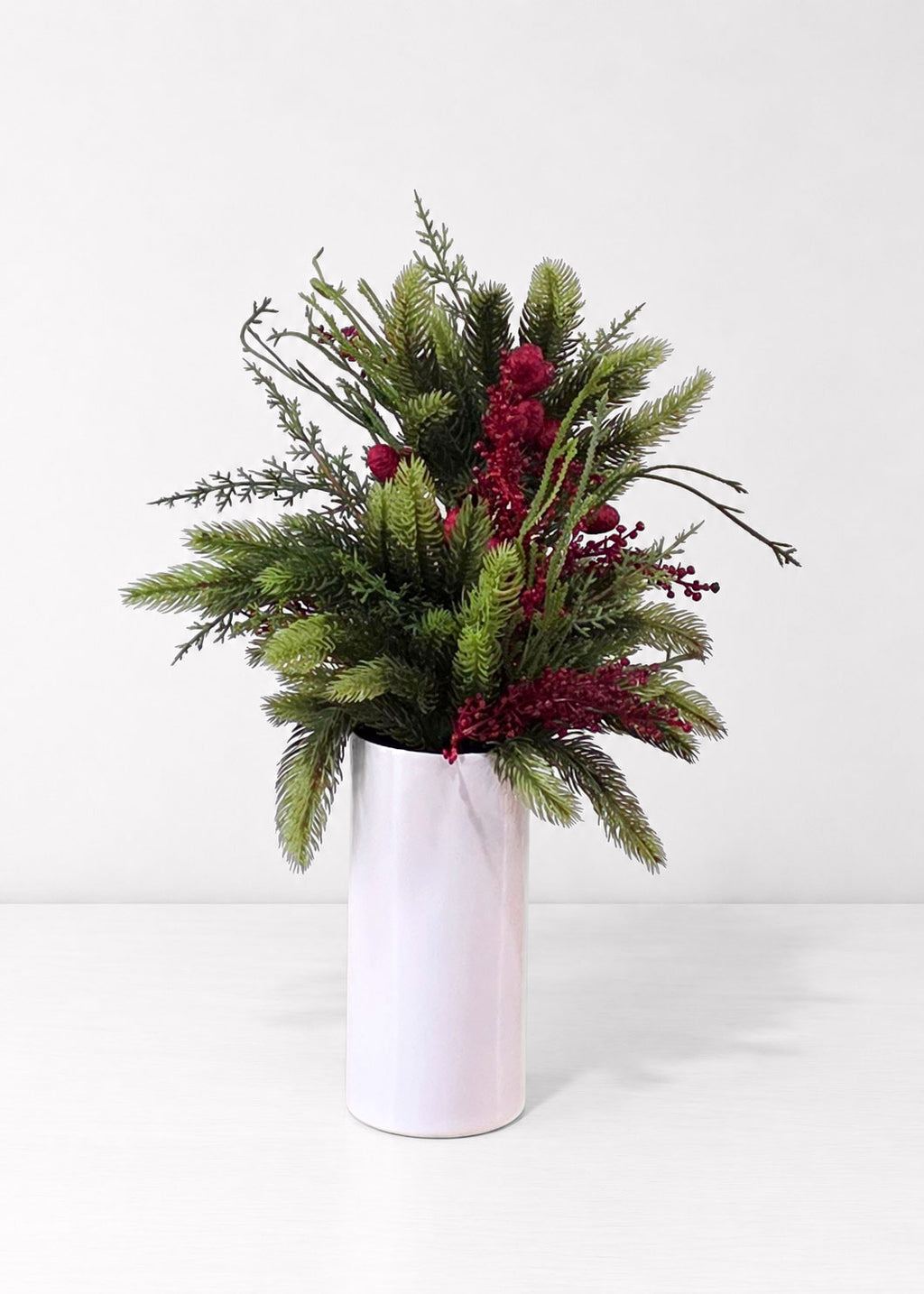 Green Fake Pine, Sedum Bush, and Red Berries in a White Vase