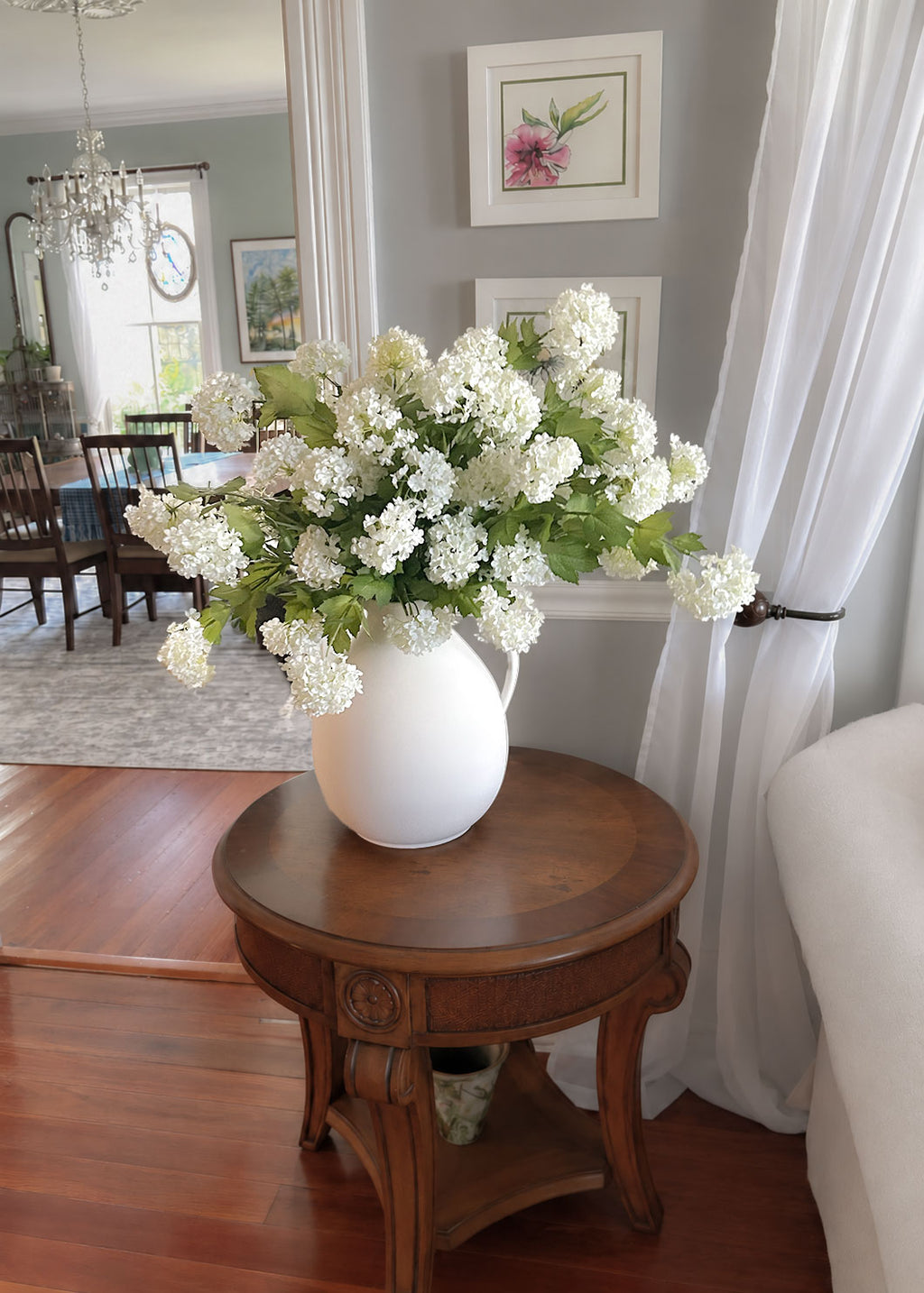 snowball bundle arranged in a white vase on a side table