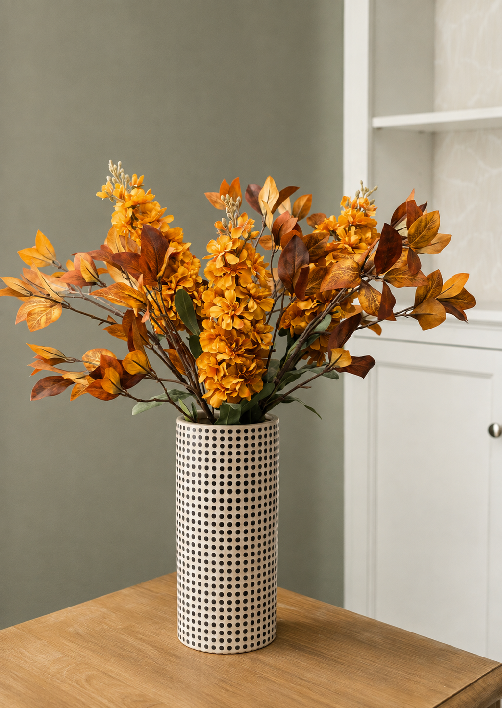 fall stock flowers and Enkianthus leaves arranged in a dotted vase