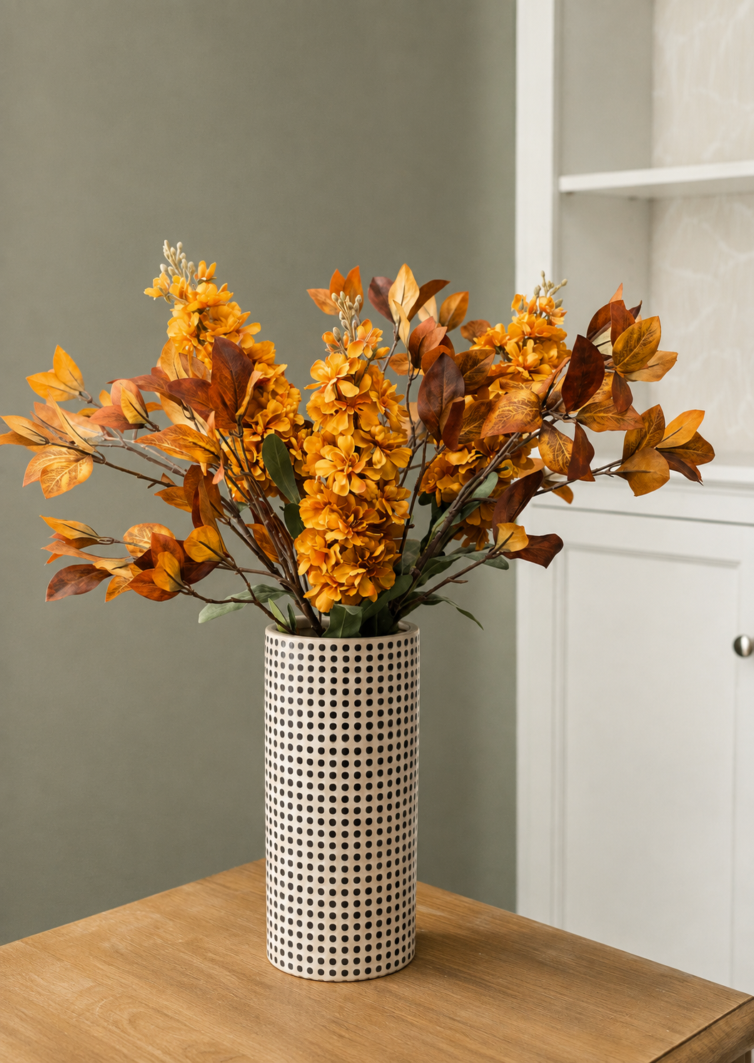 fall stock flowers and Enkianthus leaves arranged in a dotted vase