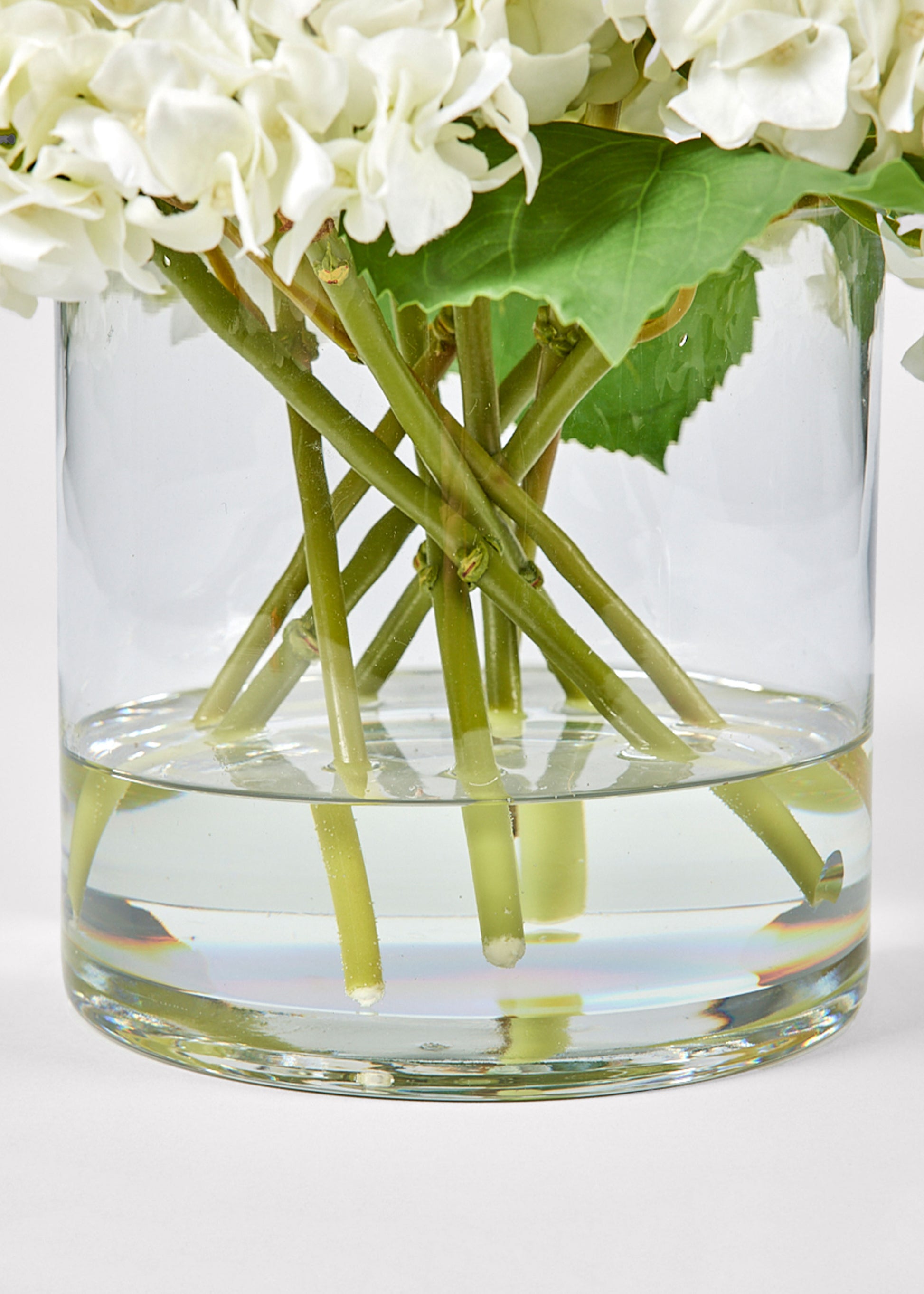 Clear glass vase with acrylic water and white flowers 