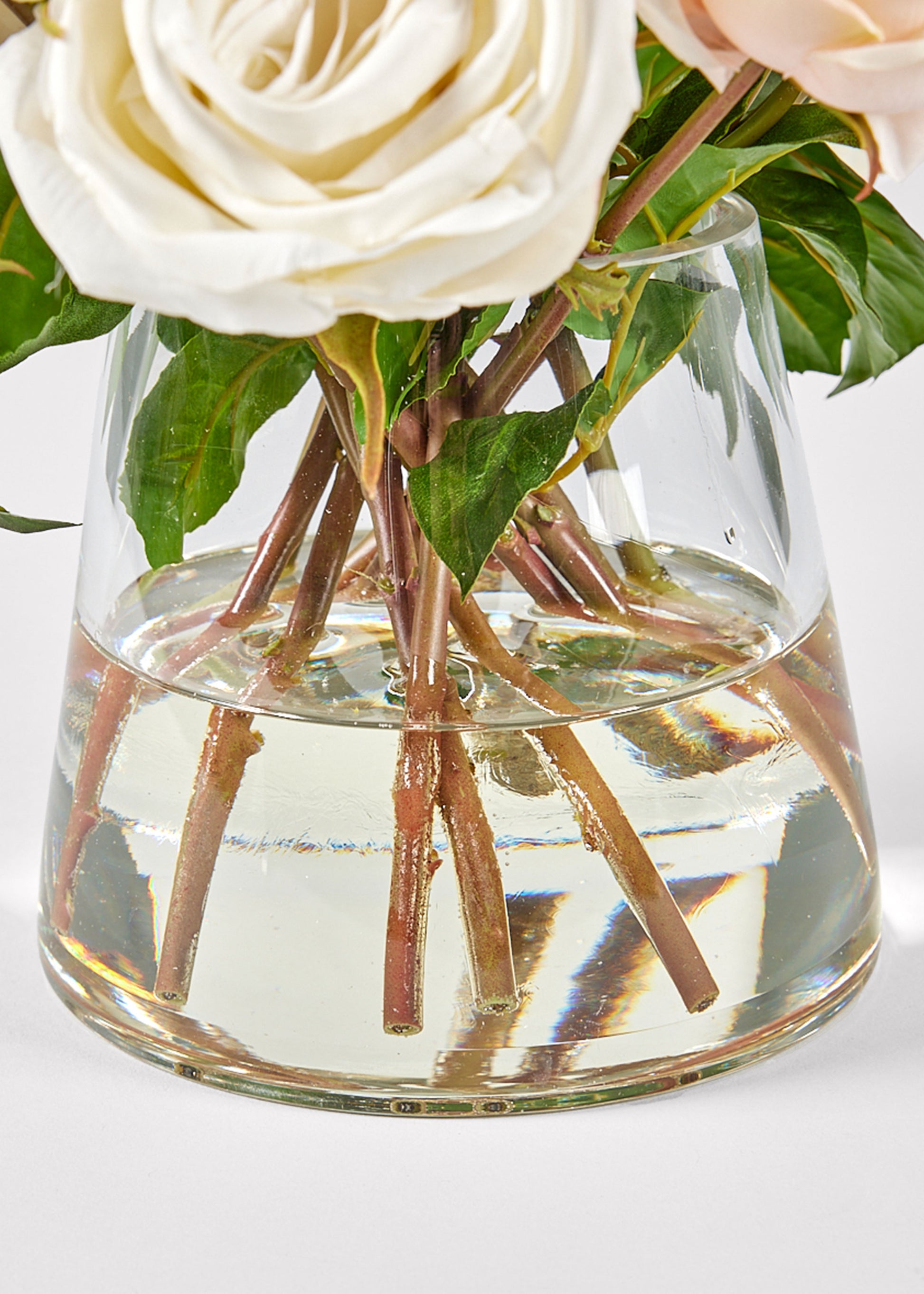 Clear glass vase with acrylic water and white roses 