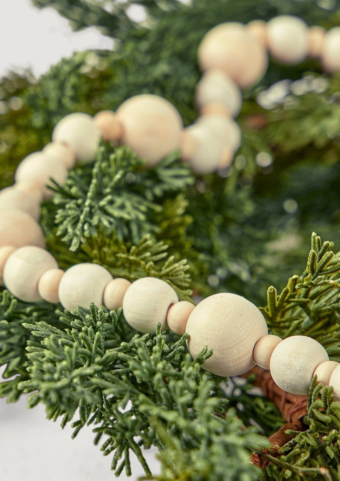 Wood Bead Christmas Garland Styled with Faux Winter Evergreens at afloral