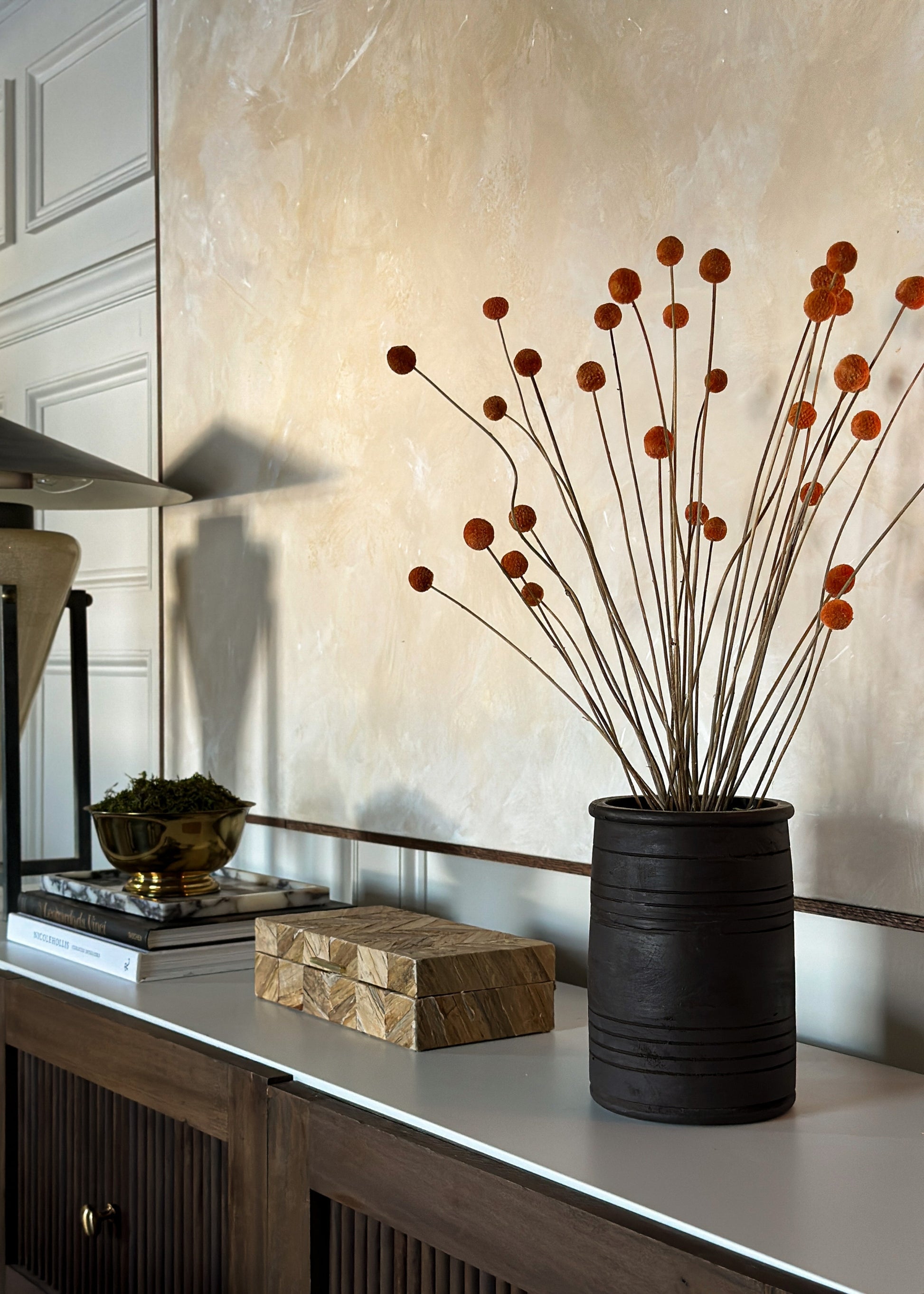 terracotta orange billy buttons styled in a vase