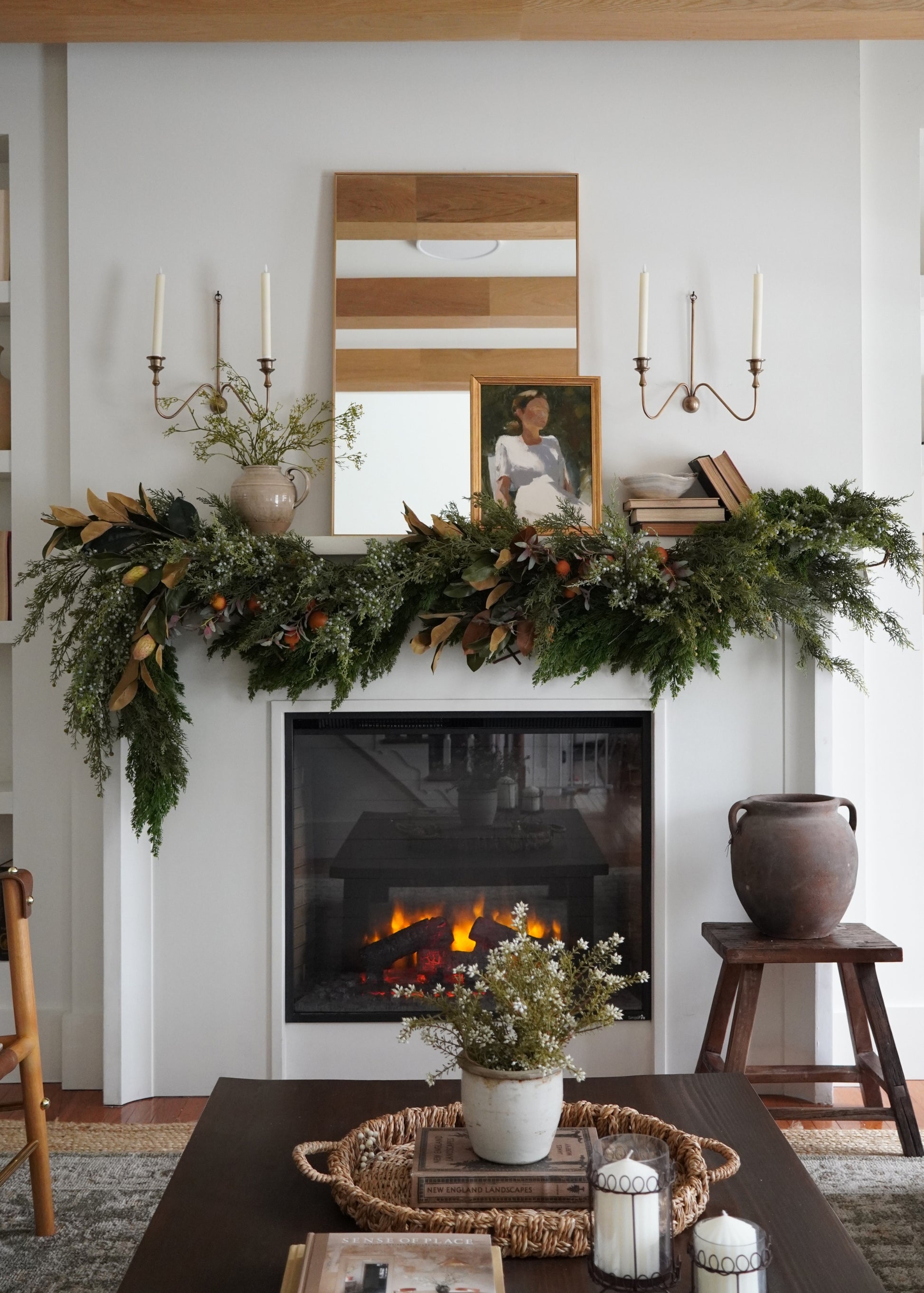 Living room with a fireplace, mantel decorated with greenery and candles