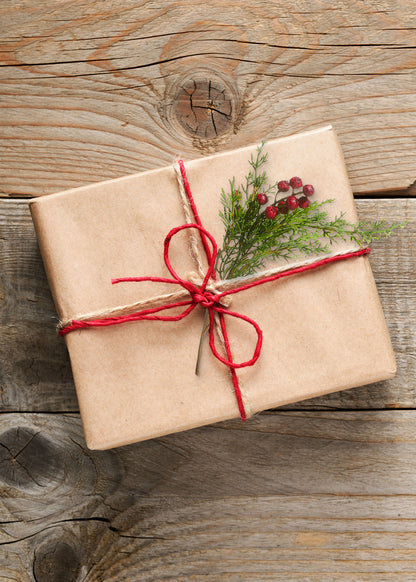 Brown paper package decorated with faux cedar and red berries