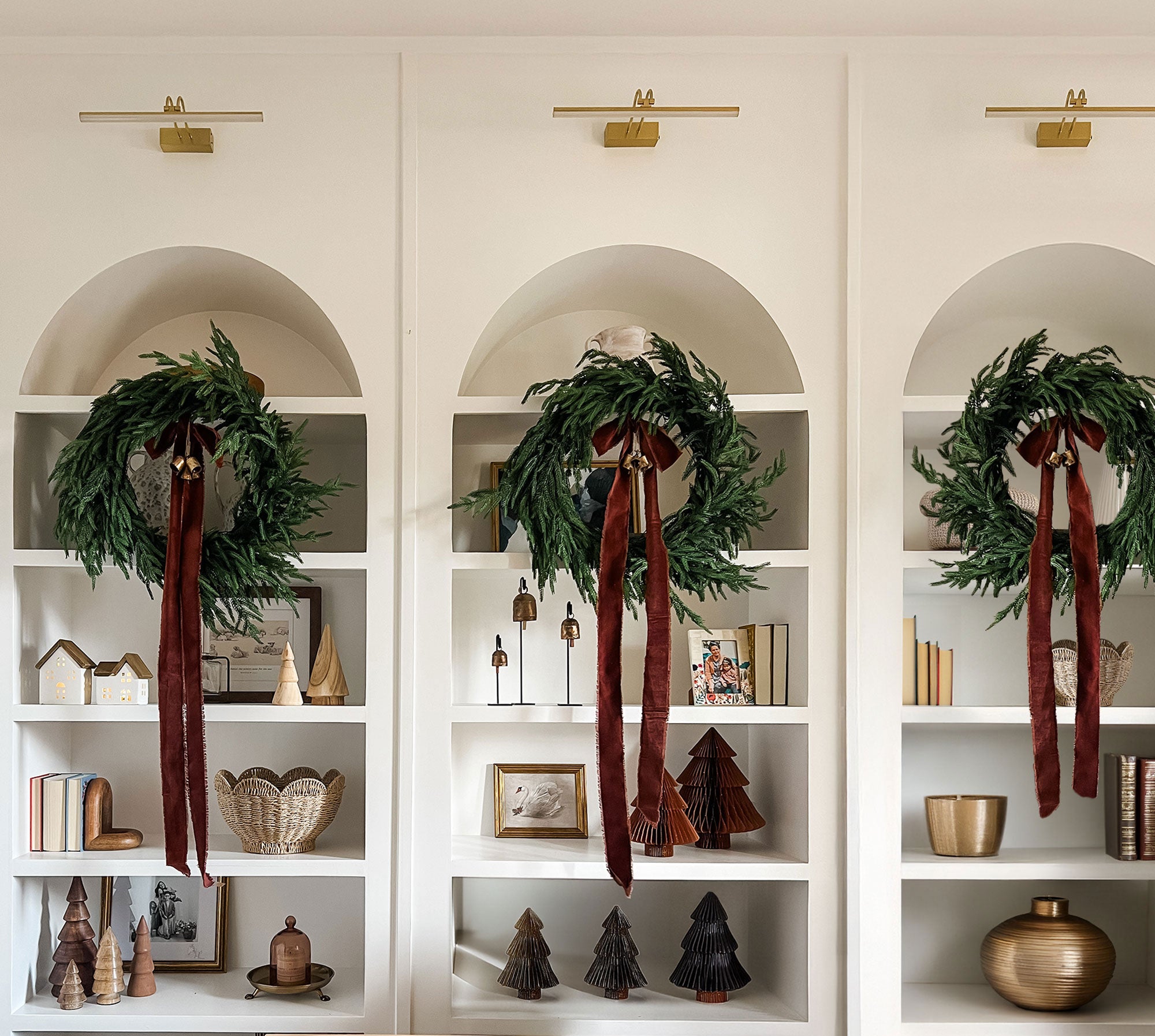 Decorative shelves with Afloral Norfolk wreaths styled with red ribbon