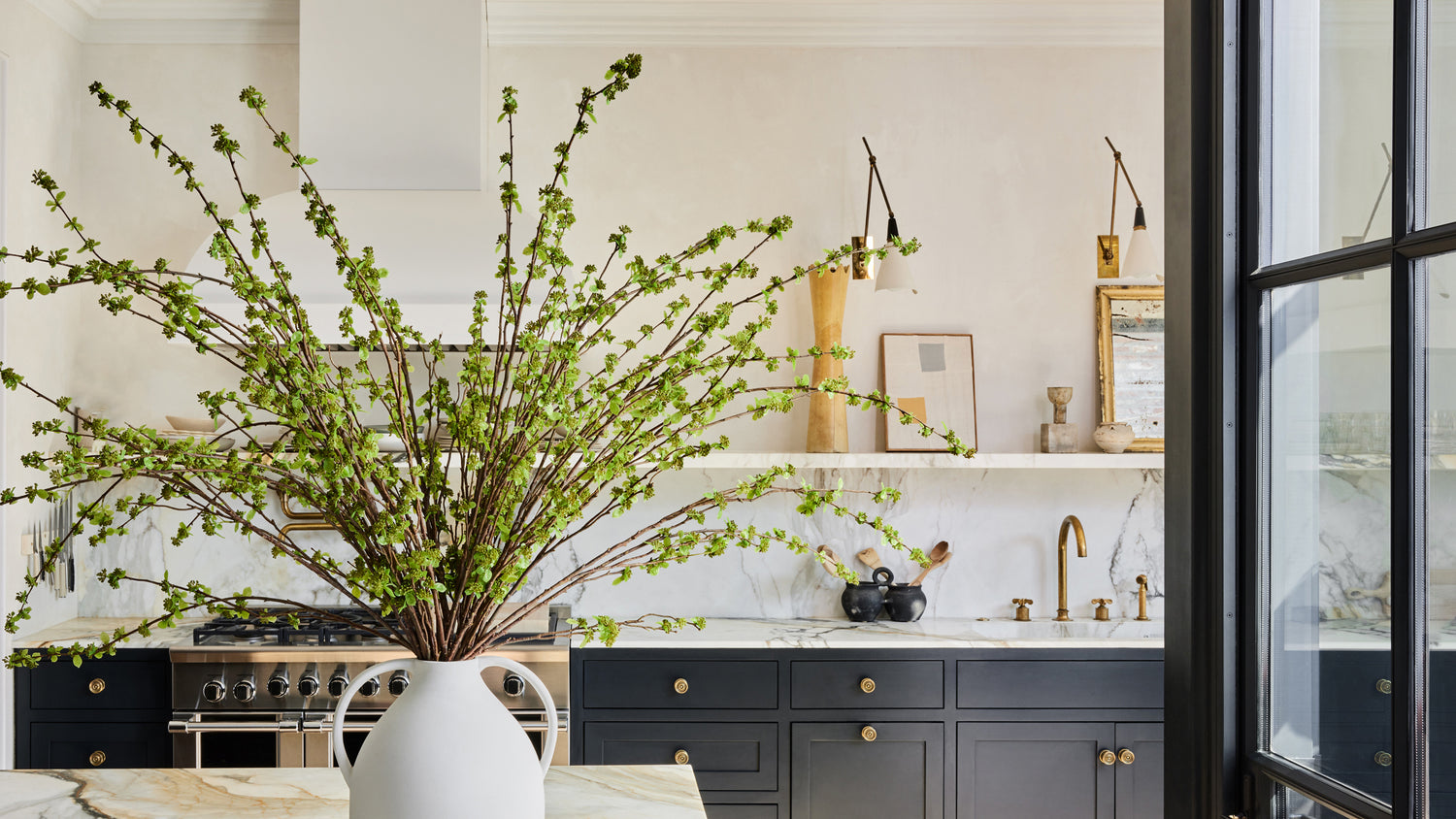 green spring budding branches in large vase in kitchen
