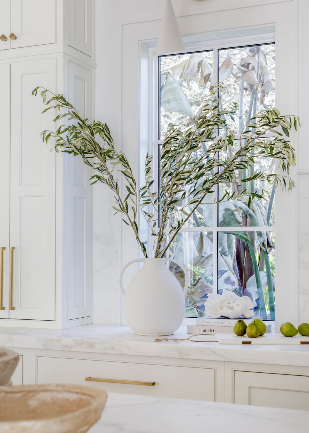 fresh cut olive branches in the afloral jug vase