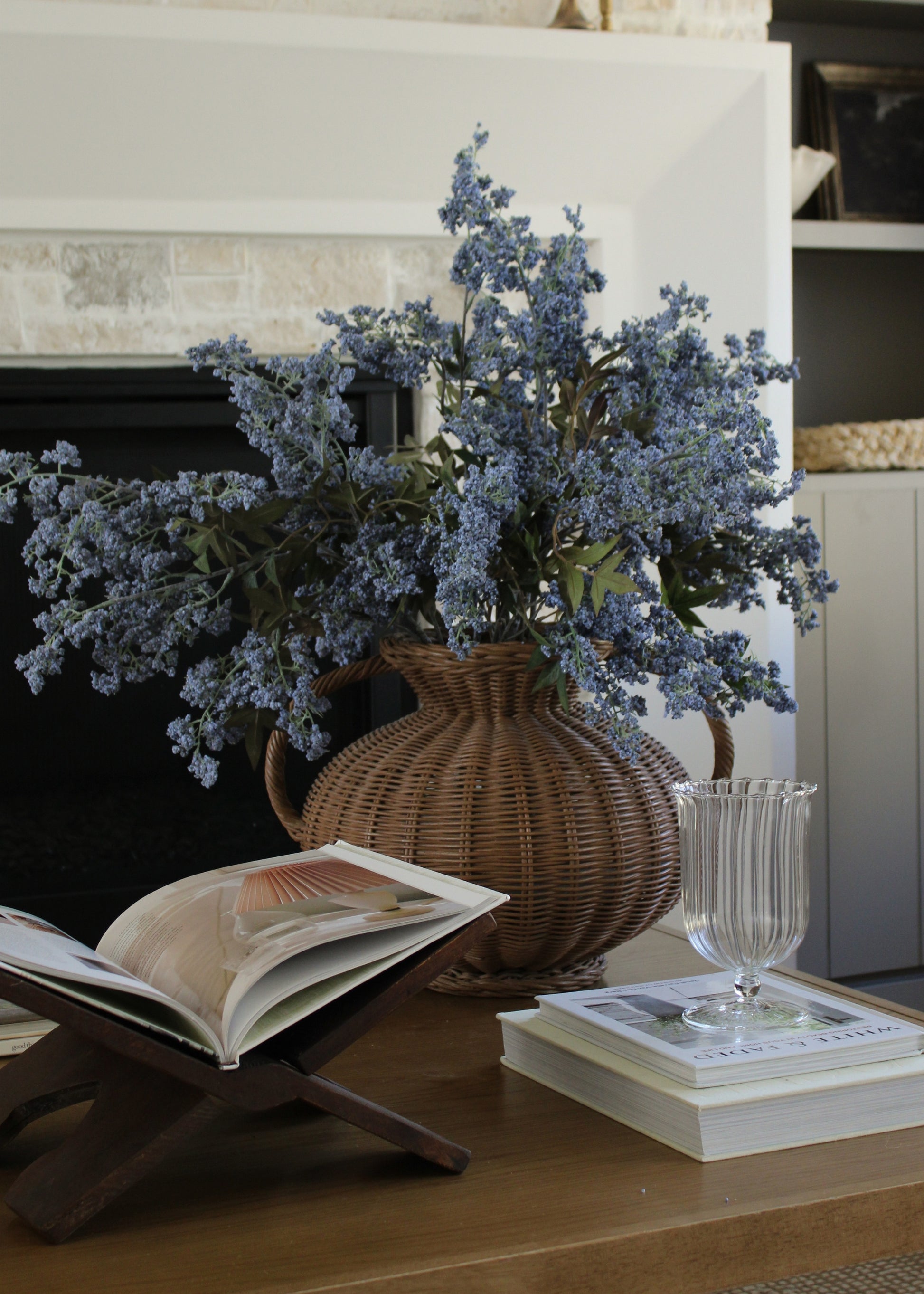 Decorative arrangement of blue flowers in a wicker vase on a coffee table