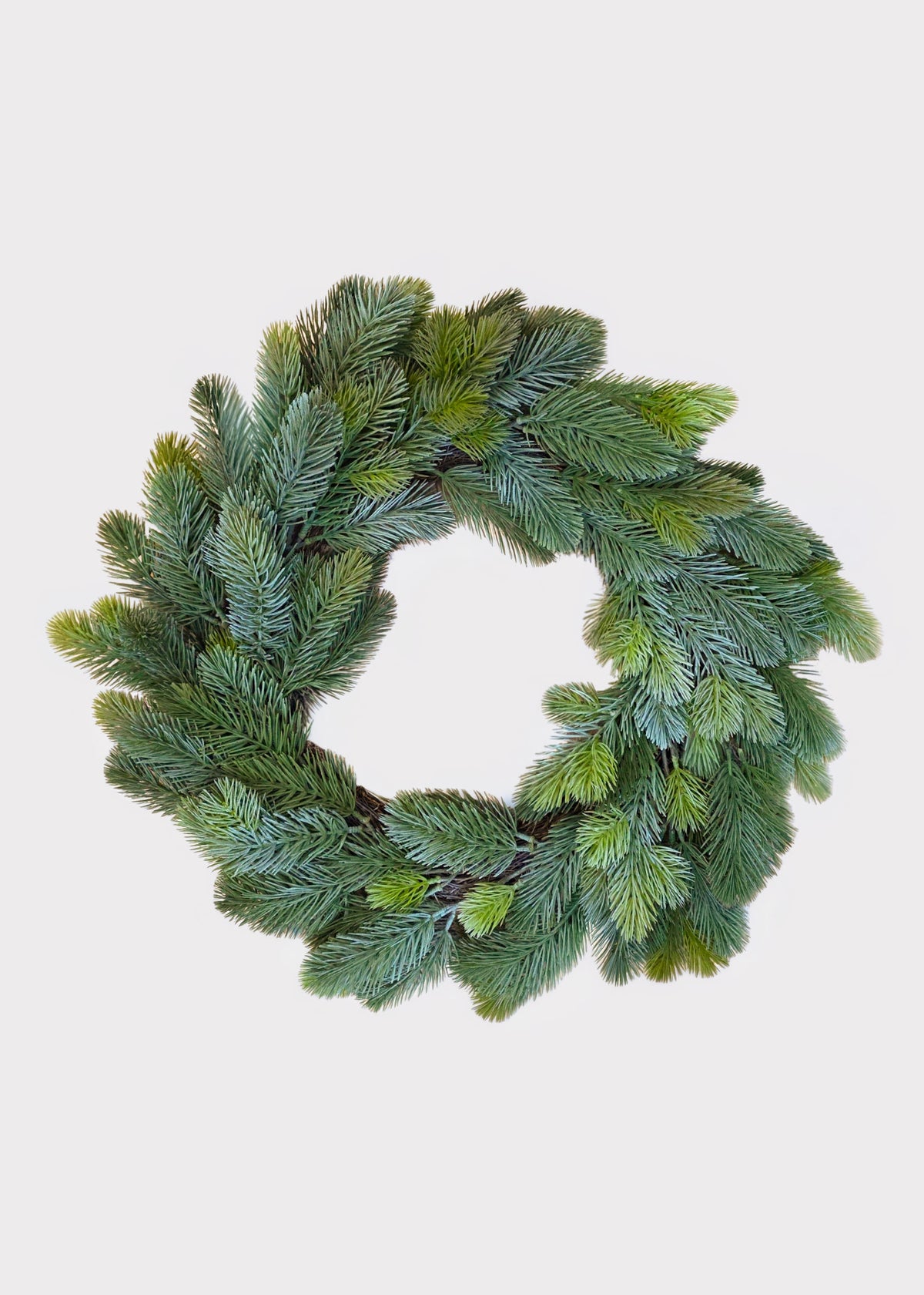 An artificial green pine wreath with realistic needle textures