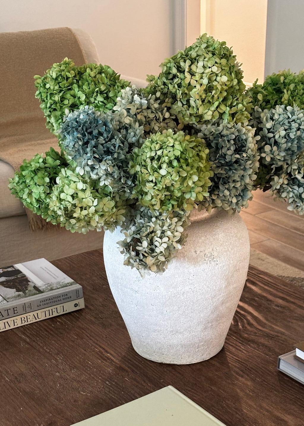 green and blue preserved hydrangeas in a vase