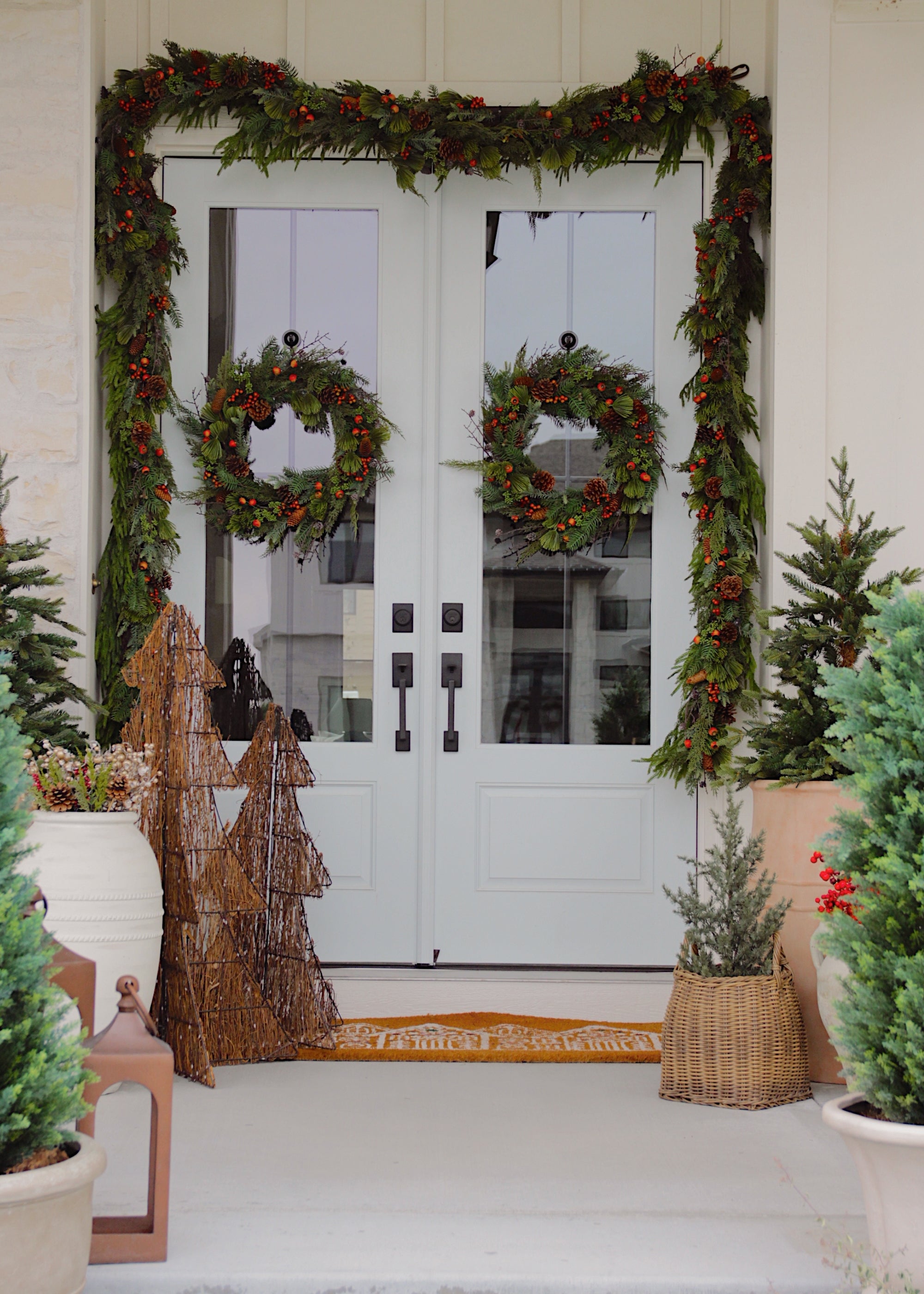 Front porch styled with faux pine wreaths and garlands