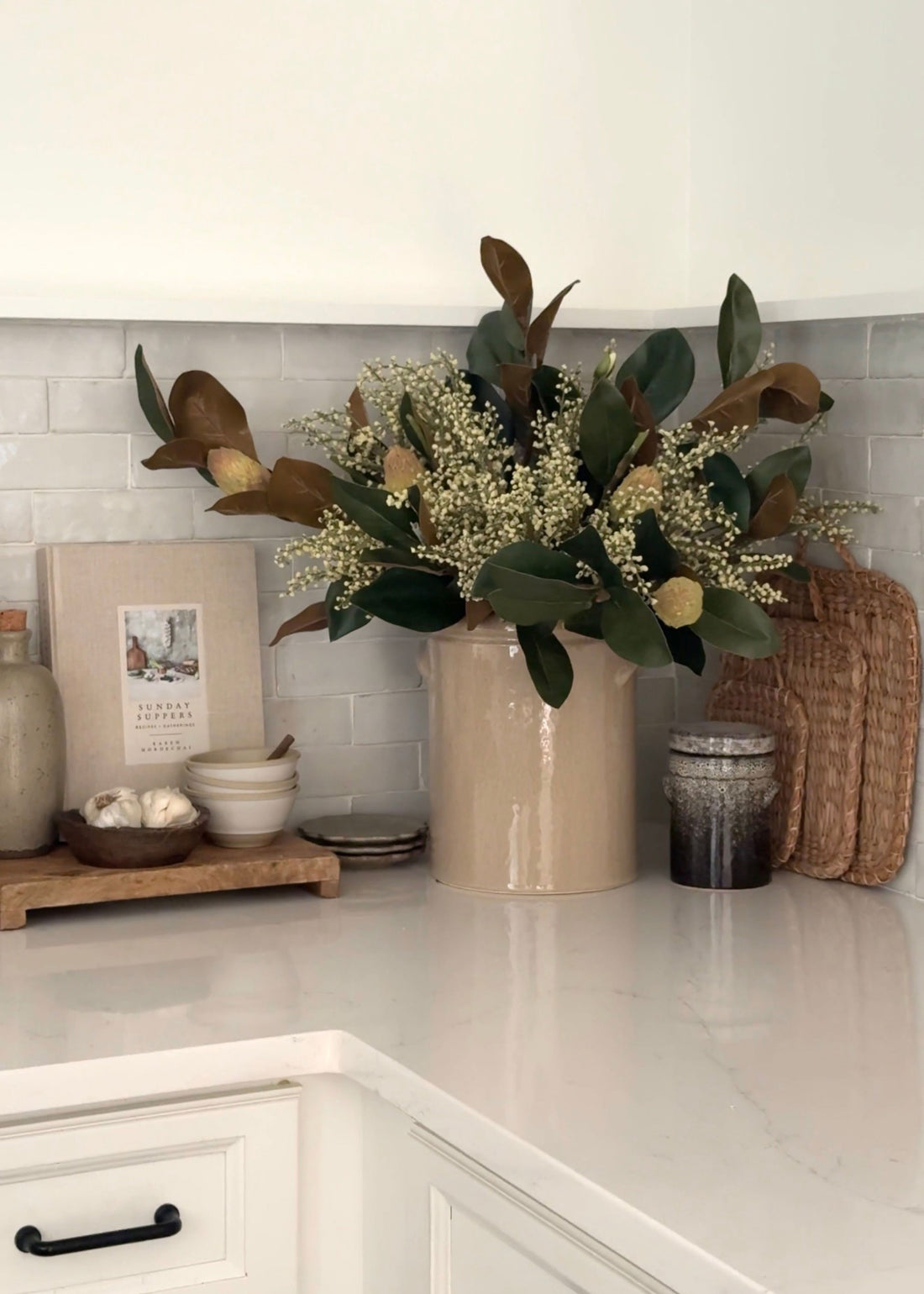 crock vase styled with magnolia branches and faux heather