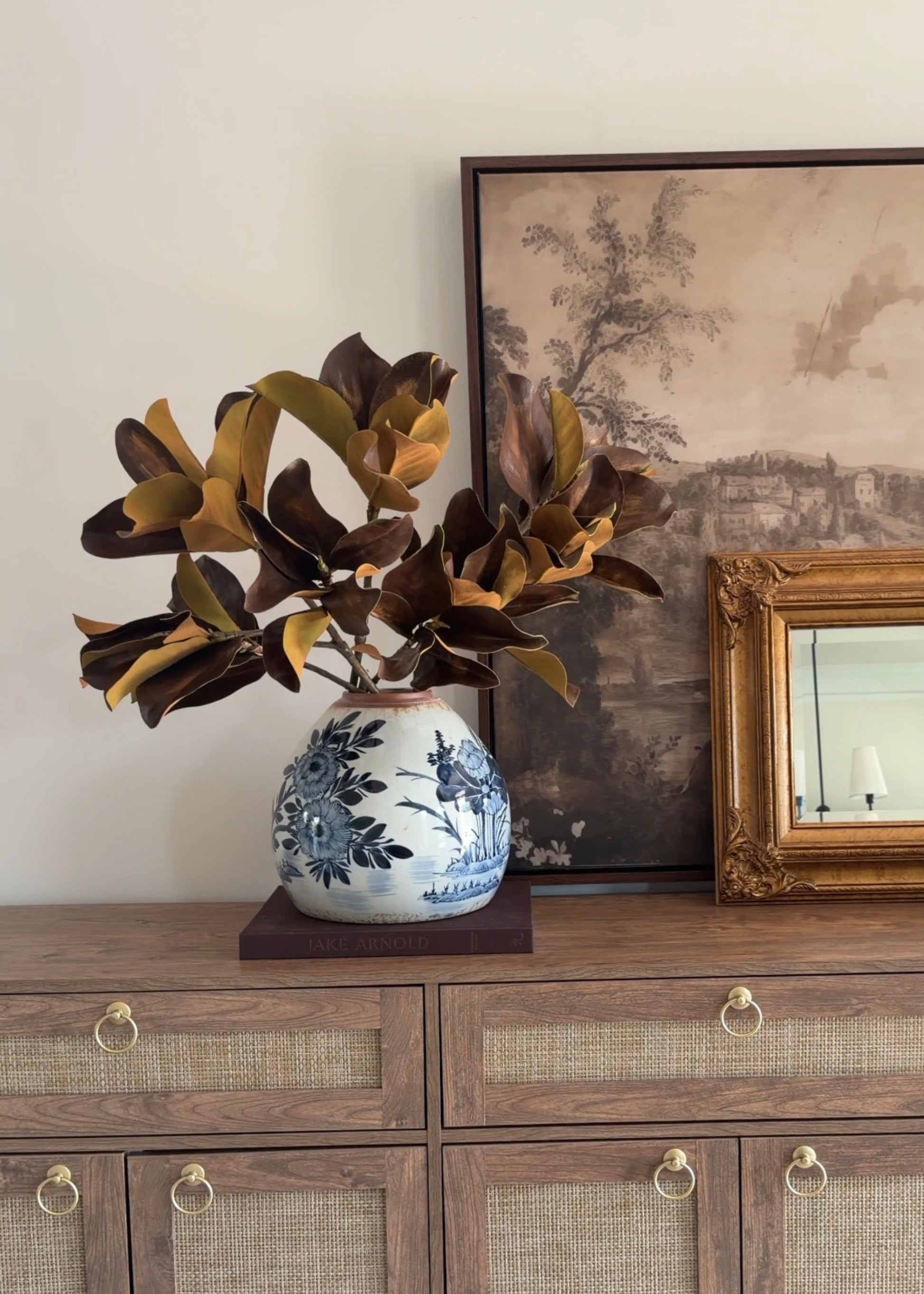 video of styling the afloral brown magnolia leaves in a blue painted vase