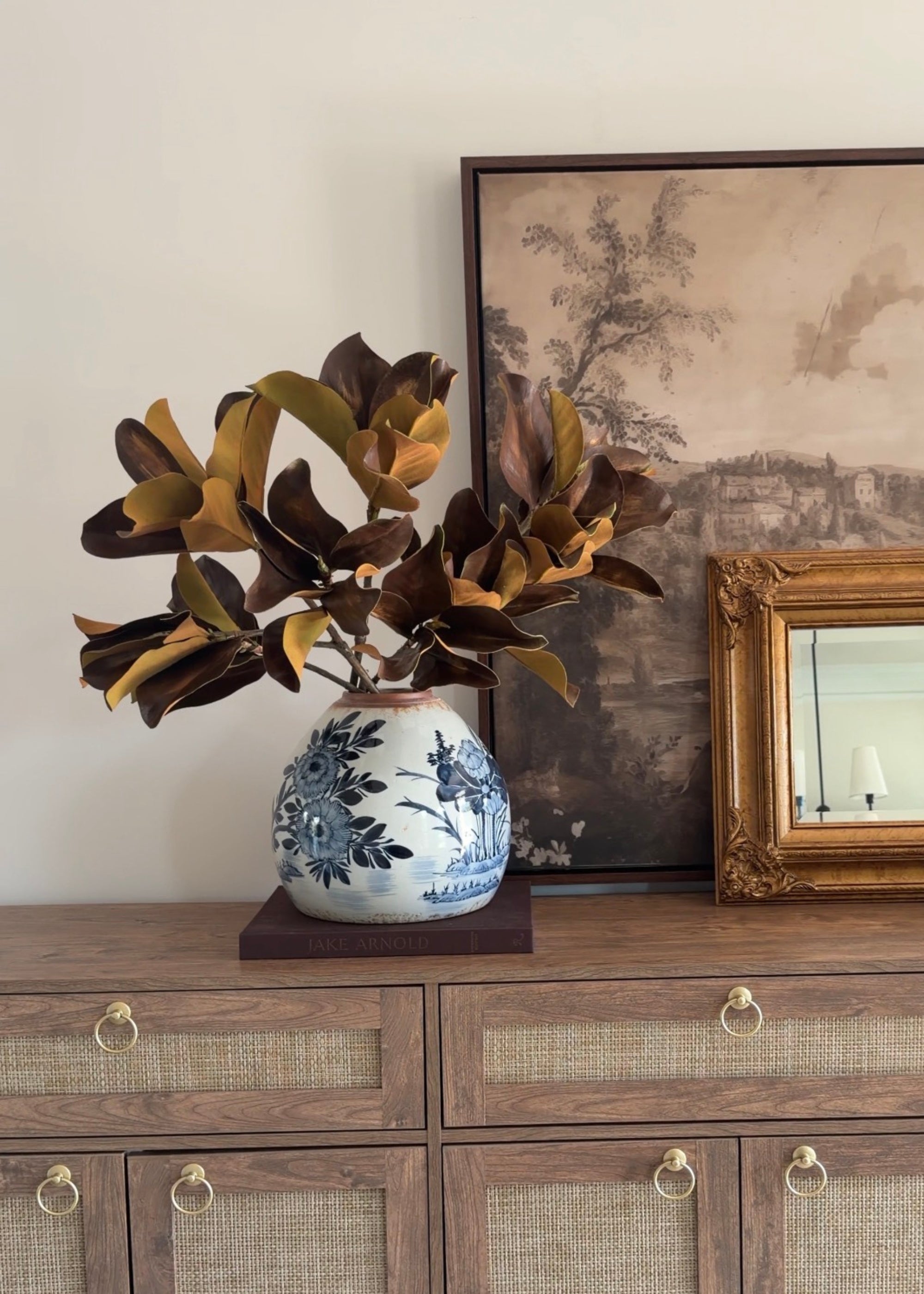 video of styling the afloral brown magnolia leaves in a blue painted vase