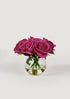 small faux arrangement of fuchsia real touch roses in round glass vase at afloral