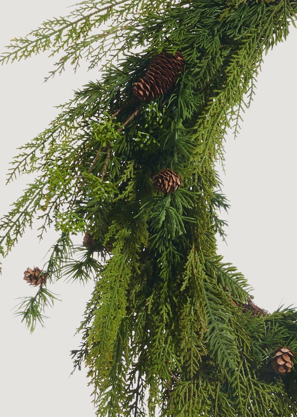 Close-up of faux cedar wreath with pine cones