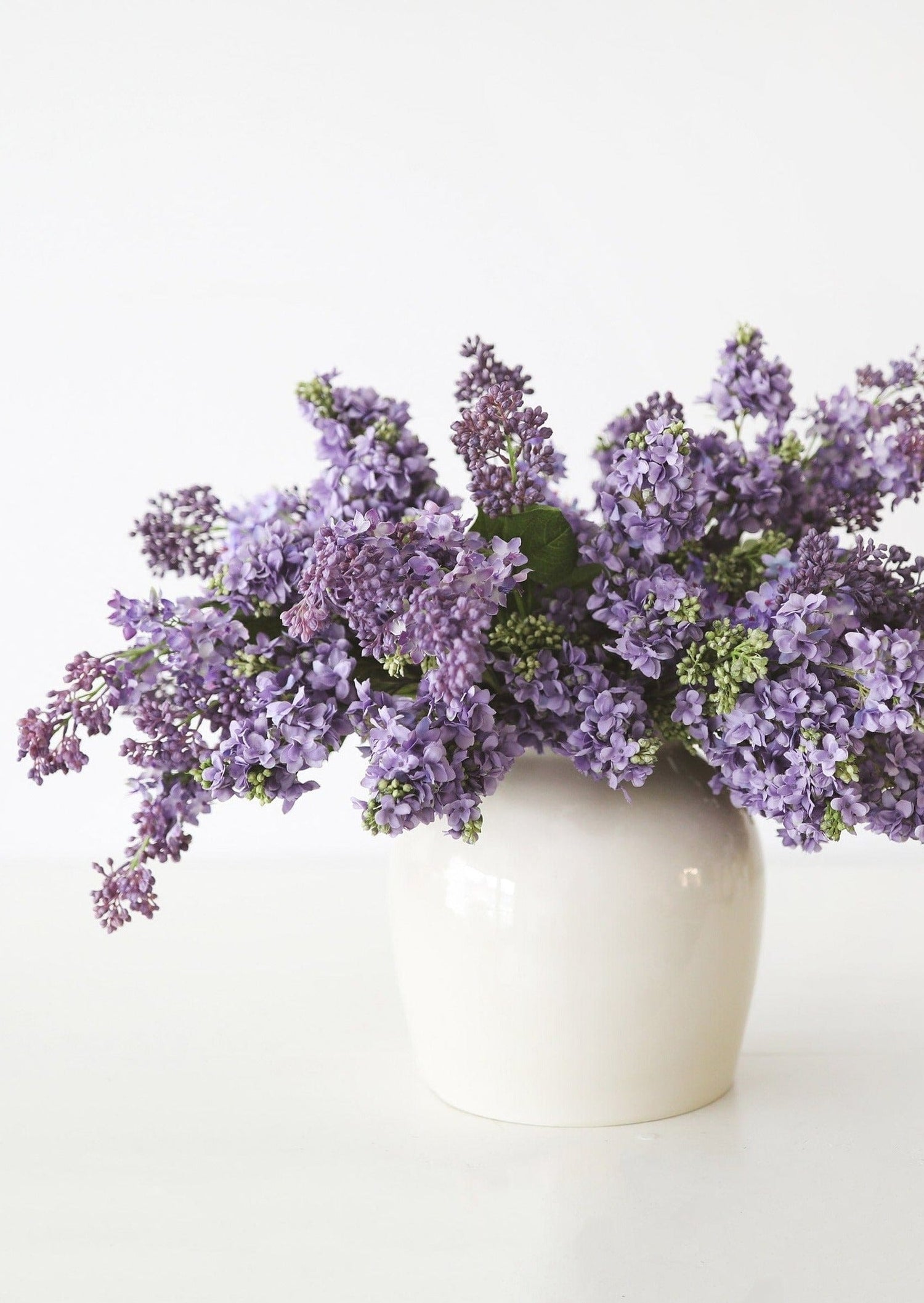 Artificial Purple Lilacs in Ceramic Cream Vase at afloral